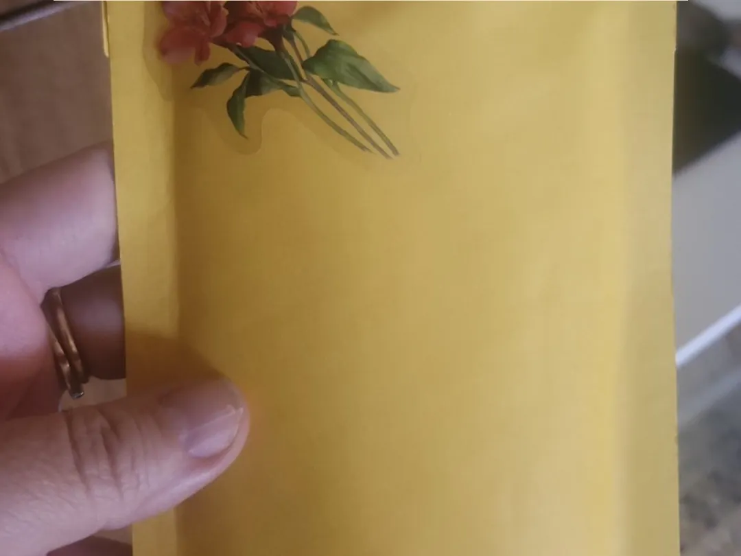 Sobre de envío decorado con una flor, listo para salir